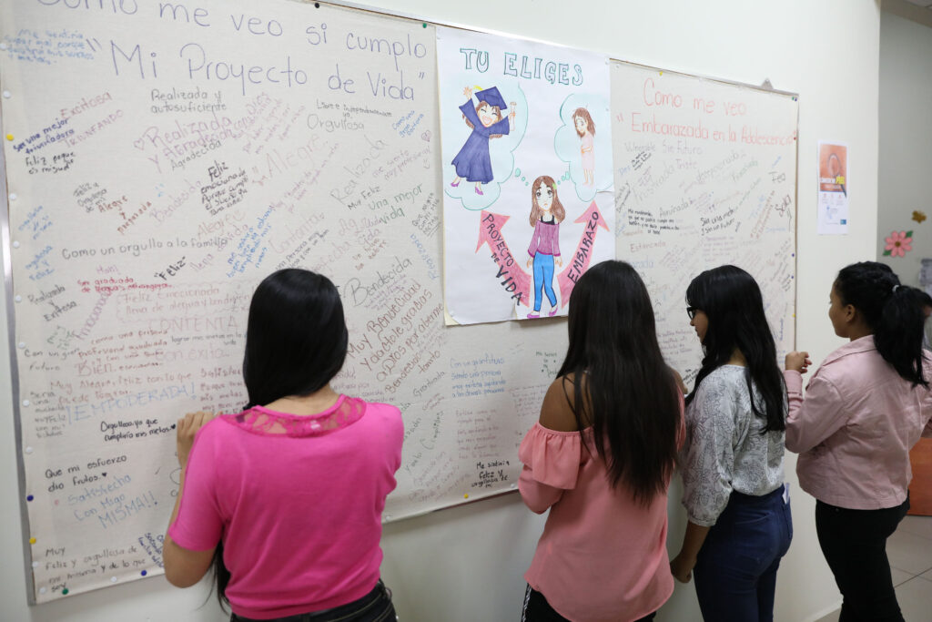 cuatro mujeres frente a una pizarra con notas sobre desarrollo profesional