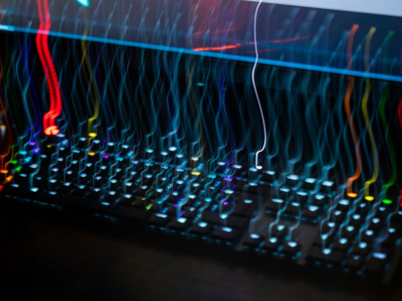 a close up of a computer keyboard with colorful lightsPhoto by Adrien on Unsplash