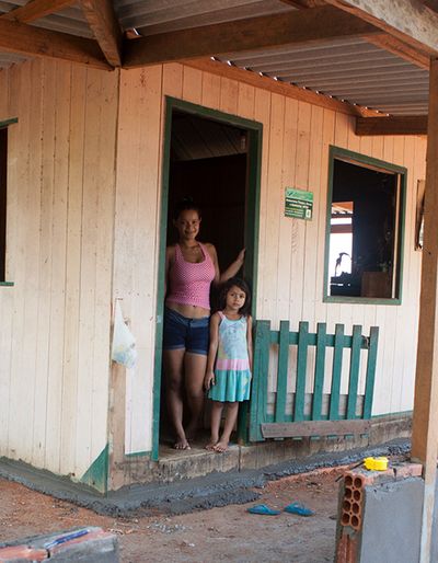 Woman and girl on the threshold of their house.