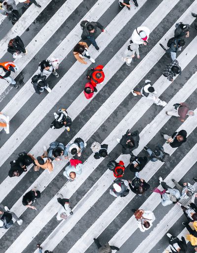 Aerial view of pedestrians crossing a marked crosswalk.