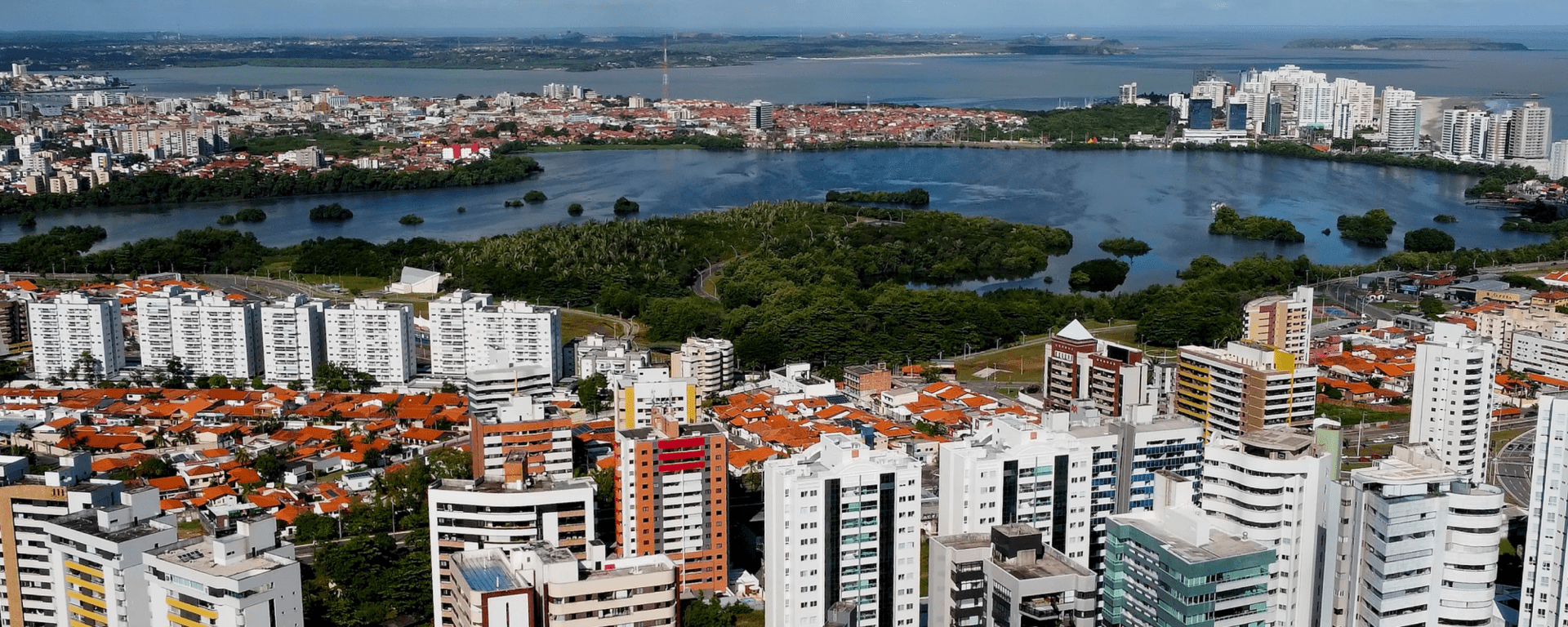 Panoramic day view of a city with buildings and a lake on the horizon - Inter American Development Bank - Public Sector
