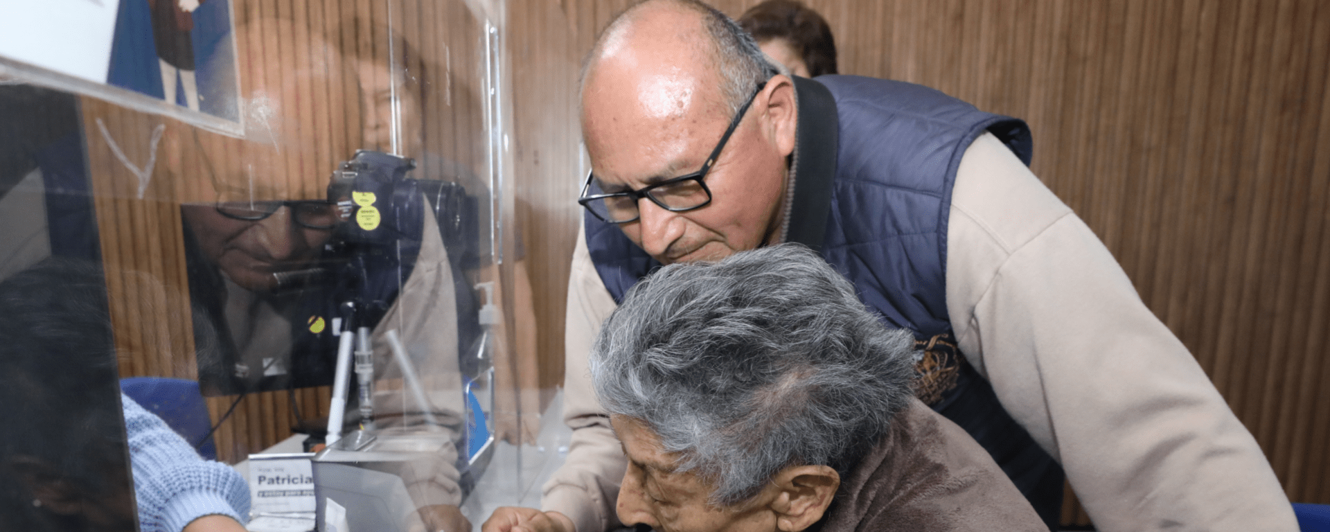 Man with an elderly woman watching a monitor - Inter American Development Bank - Public Administration