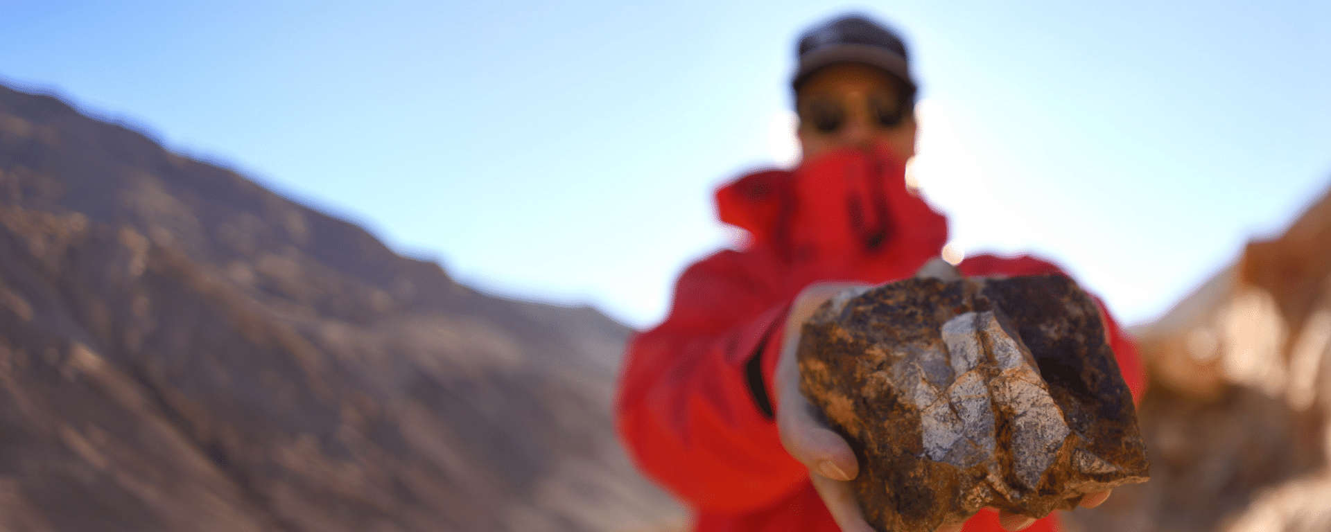 Mineral sample displayed in a mountainous landscape, representing critical minerals and natural resource development IDB