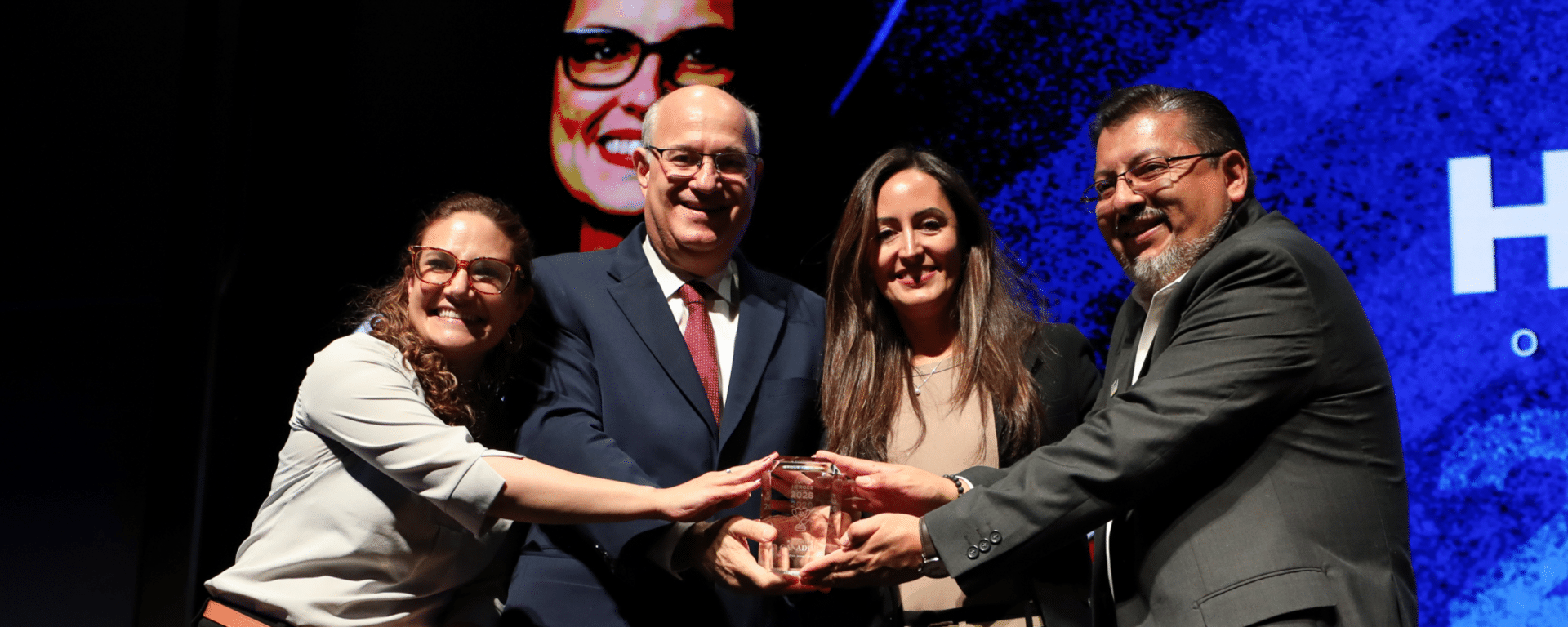 Group of individuals receiving recognition during a community leadership and social impact event IDB