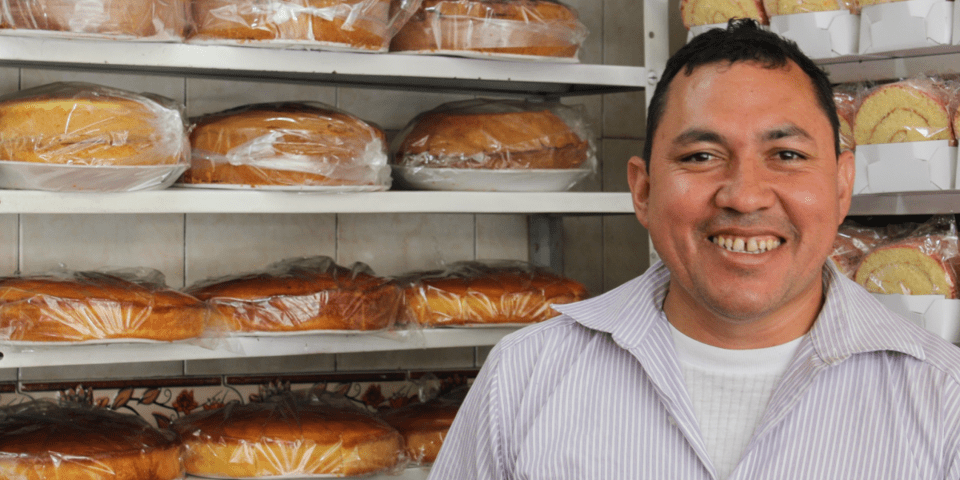 Man smiling in a bakery - Inter American Development Bank - IDB Invest