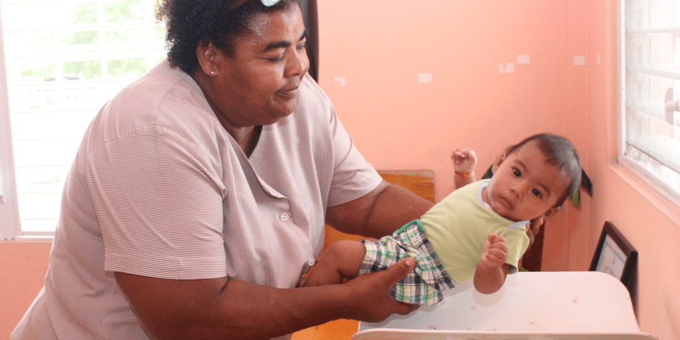 Afro-descendant woman holding a baby in her arms - Inter American Development Bank - Health