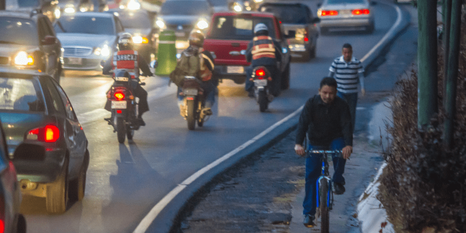 Night road with vehicles, motorcyclists and cyclists - Inter American Development Bank - Transport Infrastructure