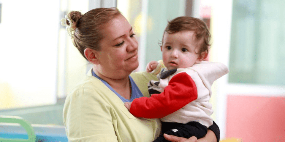 Women holding in her arms a baby - Inter American Development Bank - Early Childhood