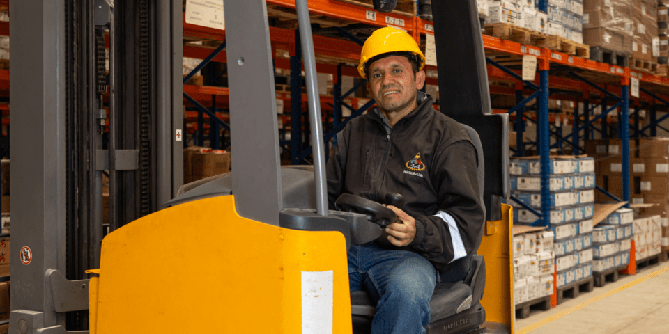Man driving an electric vehicle in a warehouse - Inter American Development Bank - Research and Development