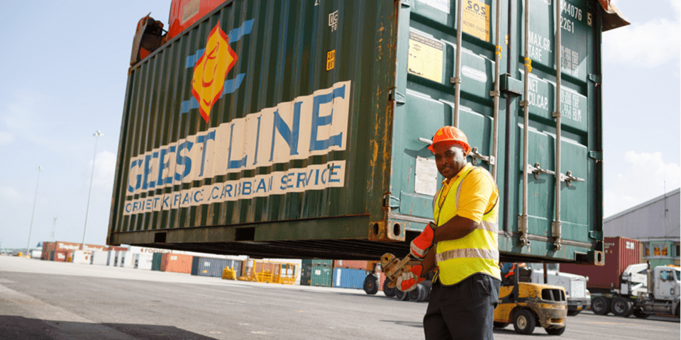 Container arriving to a port with a worker looking to a camera - Inter American Development Bank - IDB
