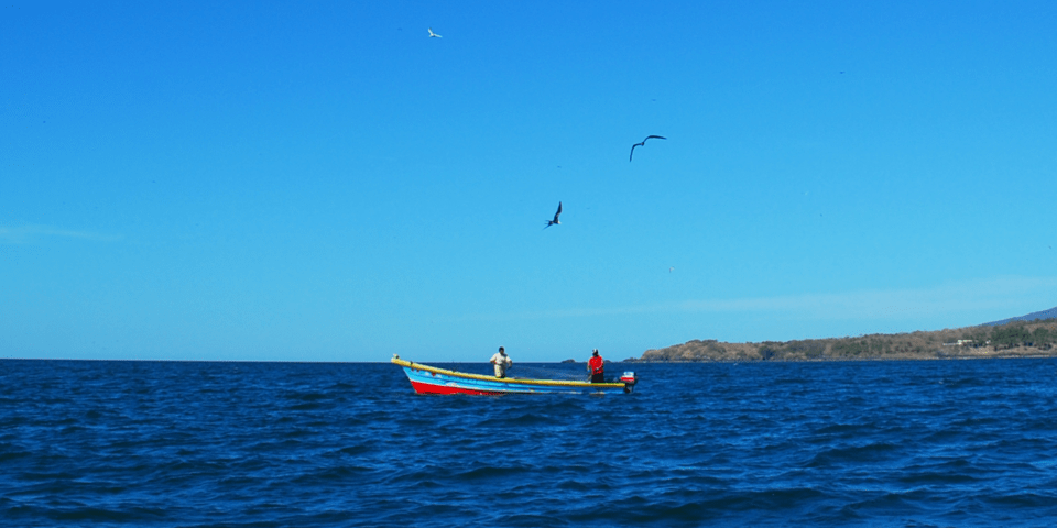 Panoramic view of a boat in the middle of the sea with mountains in the background - Inter American Development Bank - IDB Invest