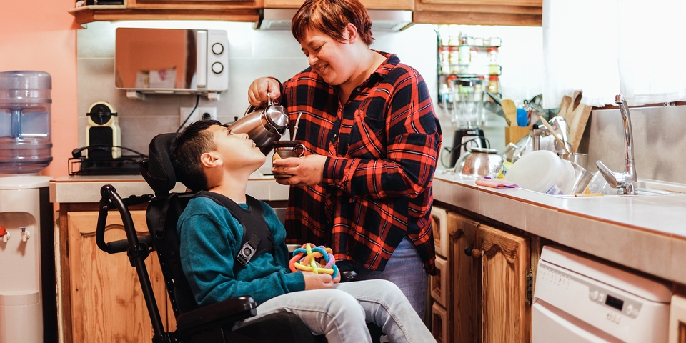 a mother feeding her child who is using a wheelchair