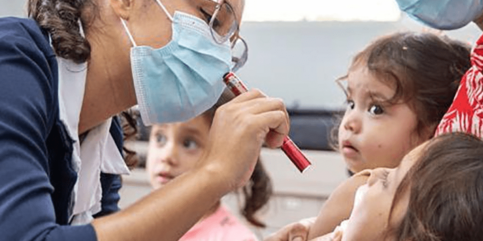 Nurse examining a girl - Inter American Development Bank - IDB Health