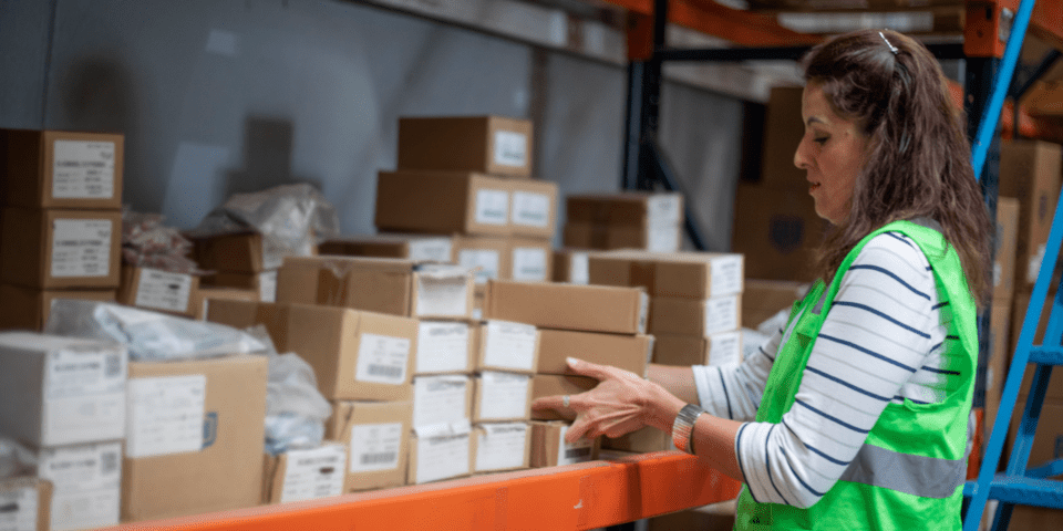 Woman organizing cardboard boxes - Inter American Development Bank - Export Activity