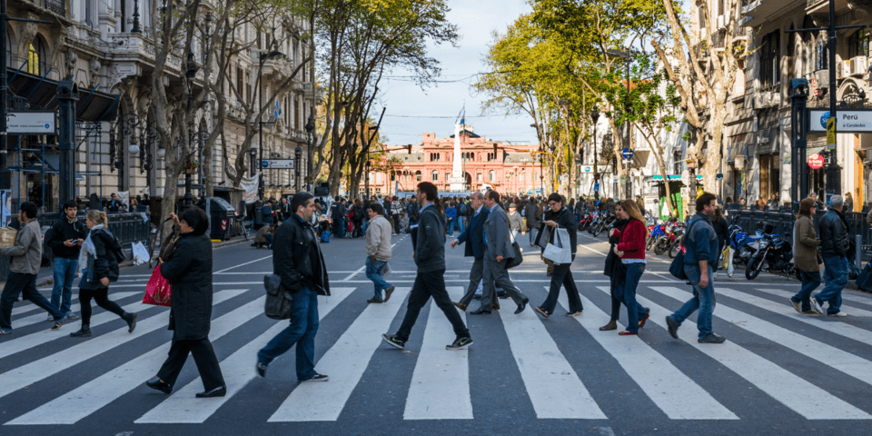 People walking on a crosswalk on a main city street- Inter American Development Bank - Alliance for Security, Justice and Development