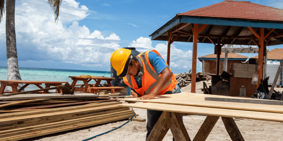Women holding in her arms a table with a beach background - Inter American Development Bank - Natural Disaster