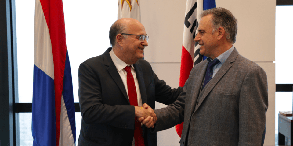 Ian Goldfjan shaking hands with another person, inside a conference room - Inter American Development Bank - Private and Public Sector