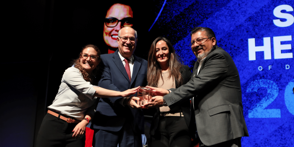 Group of individuals receiving recognition during a community leadership and social impact event IDB