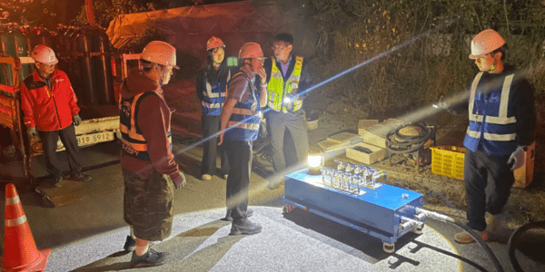 Ingenieros inspeccionan equipos de gestión inteligente del agua durante operaciones de campo nocturnas con monitoreo en tiempo real