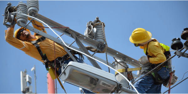 Técnicos realizan mantenimiento en una estructura de distribución eléctrica.
