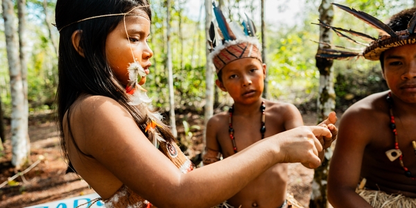 An Indigenous girl and two Indigenous boys in the Brazilian Amazon.