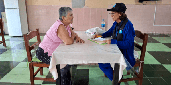 Mujer adulta administra una encuesta a una mujer adulta mayor. 