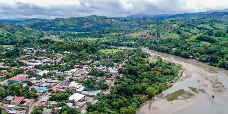 A city surrounded by trees and a river - Inter-American Development Bank - IDB