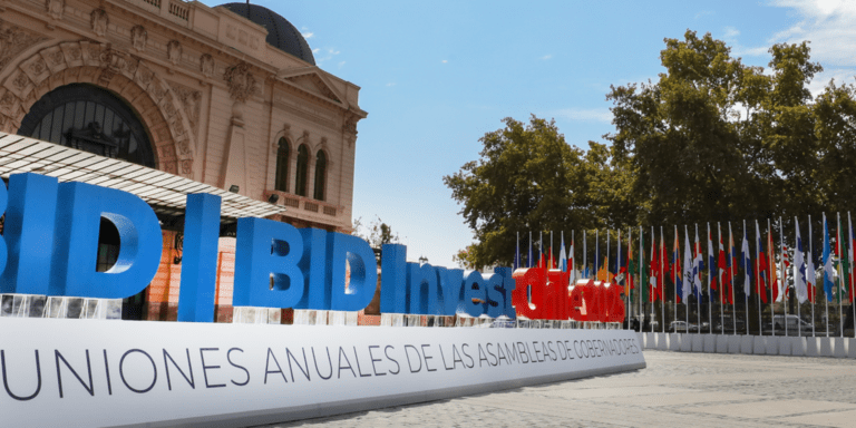 Medium shot of a square with a large BID sign and country flags - Inter American Development Bank - Annual Meetings