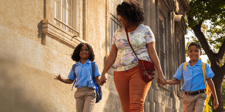 Afro-descendant woman walking with her children down a street - Inter American Development Bank - Impact Framework