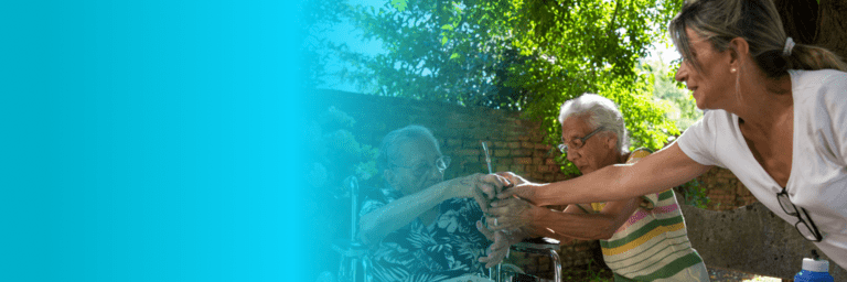 Woman in a wheelchair and adult women holding hands - Inter American Development Bank - Long-Term Care