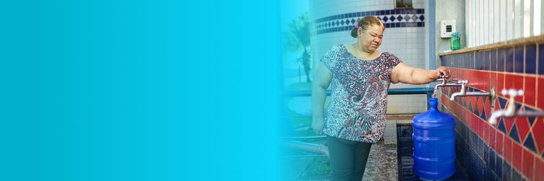 Elderly woman turning on water tap - Inter American Development Bank - Water and Sanitation