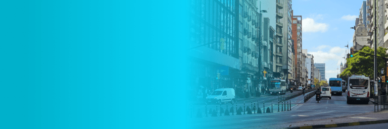 City street with buildings, buses and vehicles around - Inter American Development Bank - Transport Infrastructure