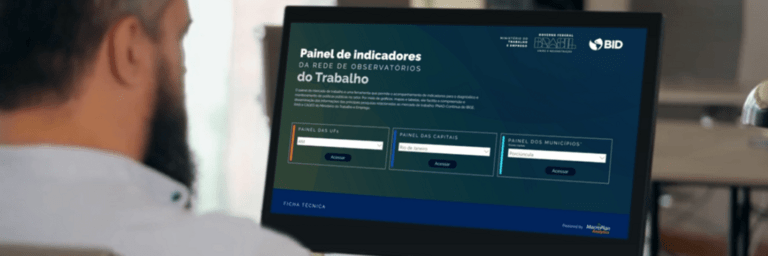 Man sitting with his back watching to a desktop computer screen - Inter American Development Bank - Labor Markets