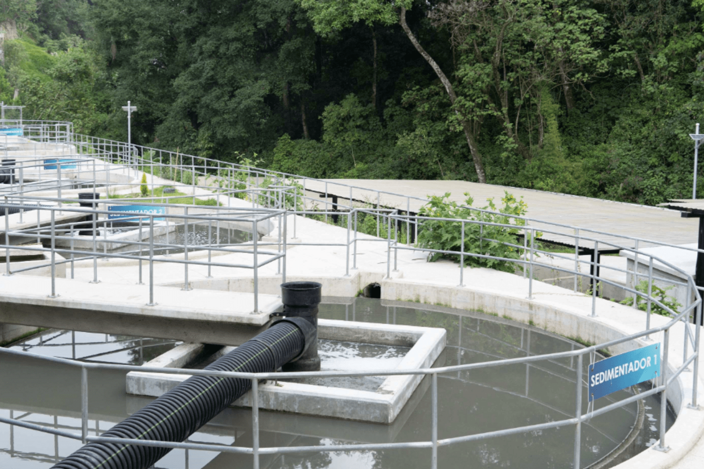Planta de tratamiento de agua con tanques circulares y camiones, destacando procesos de saneamiento innovadores.