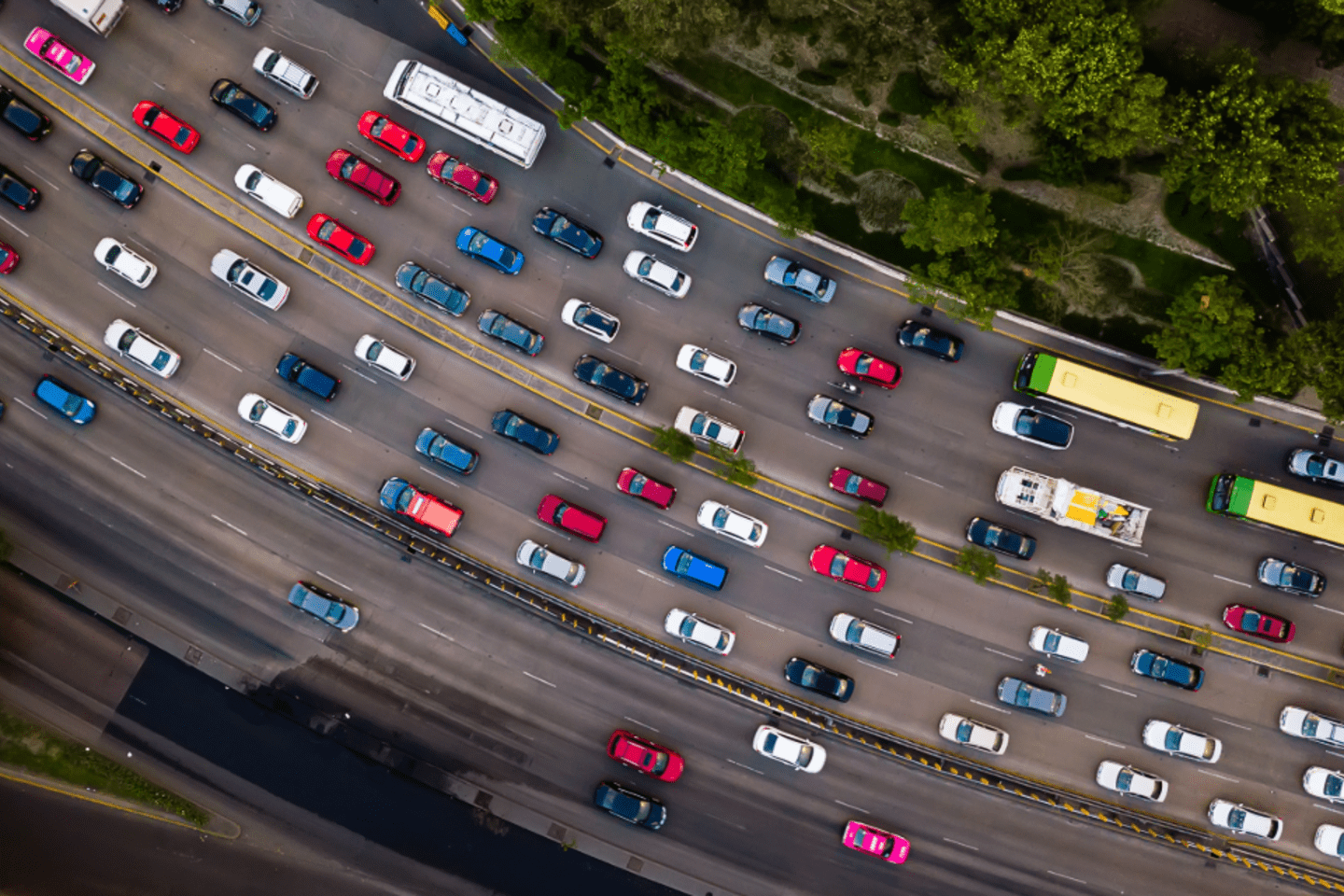 Vista aérea de una autopista con alto tráfico vehicular, ilustrando los desafíos climáticos y la necesidad de avanzar hacia un transporte más limpio y resiliente.