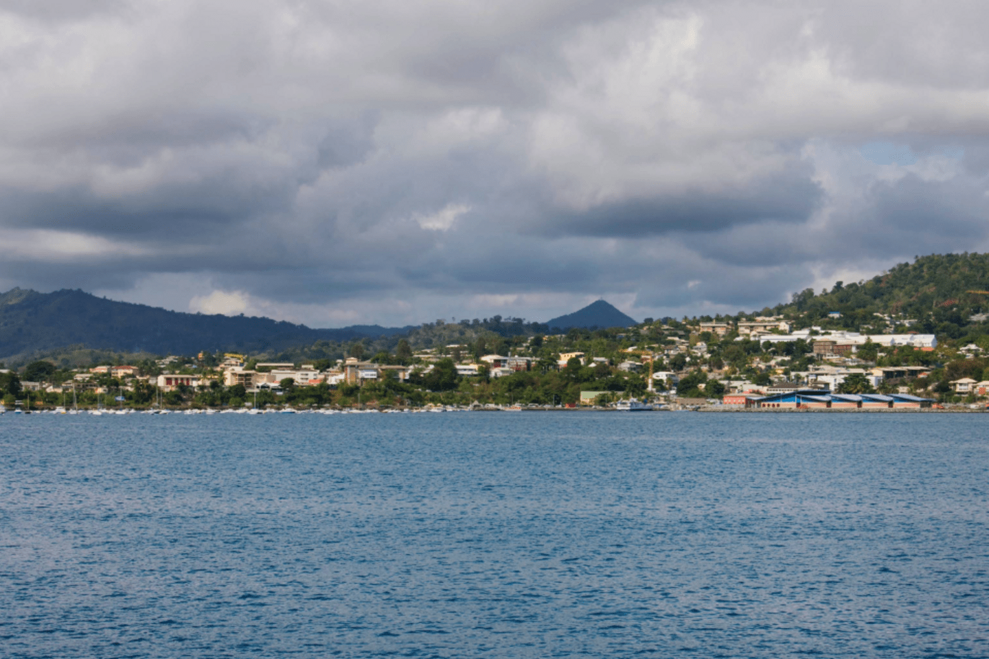 A wide shot of the waterfront capital city in the Caribbean from the sea on water utility insurance collective following hurricane.