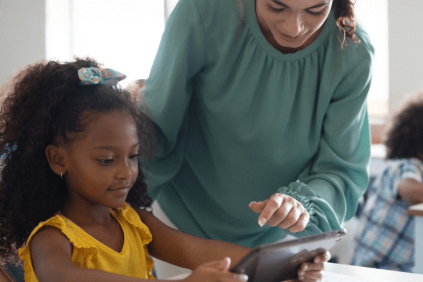 student and teacher use tablet together 