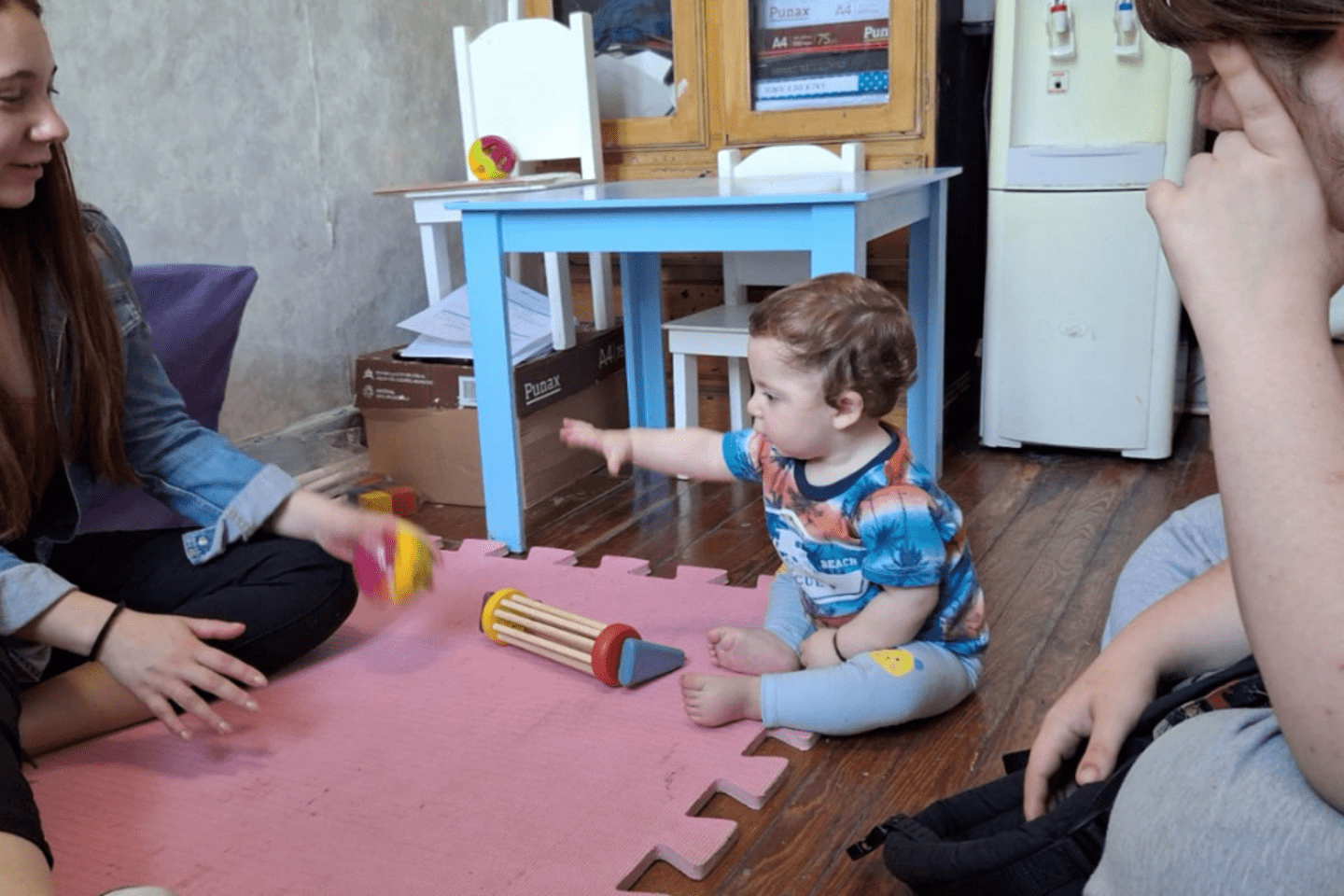 two women watching a baby