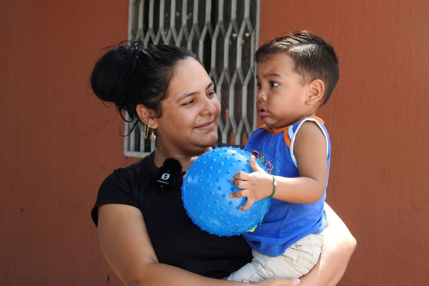 Uma mulher carregando seu filho pequeno