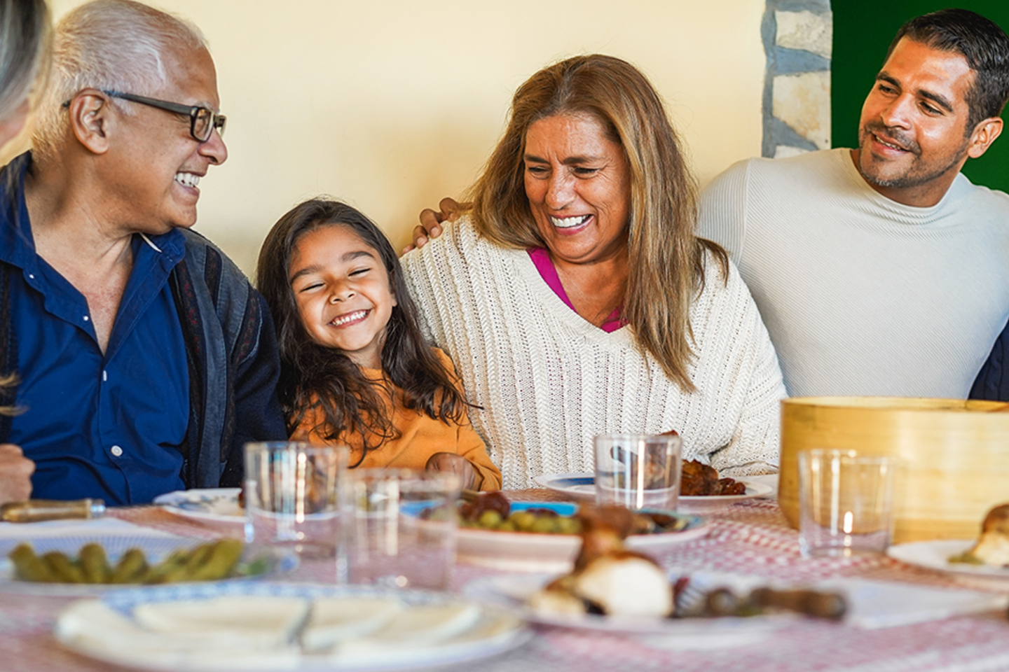 Latin family sitting at a table smiling