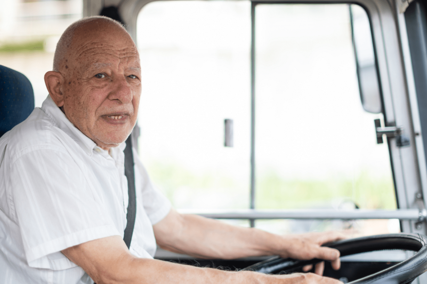 old man driving a bus 