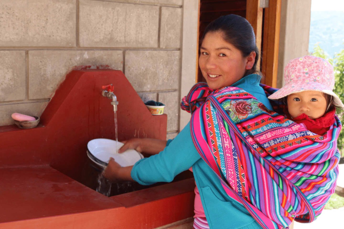 A mother and her child doing domestic chores in a rural setting in Latin America