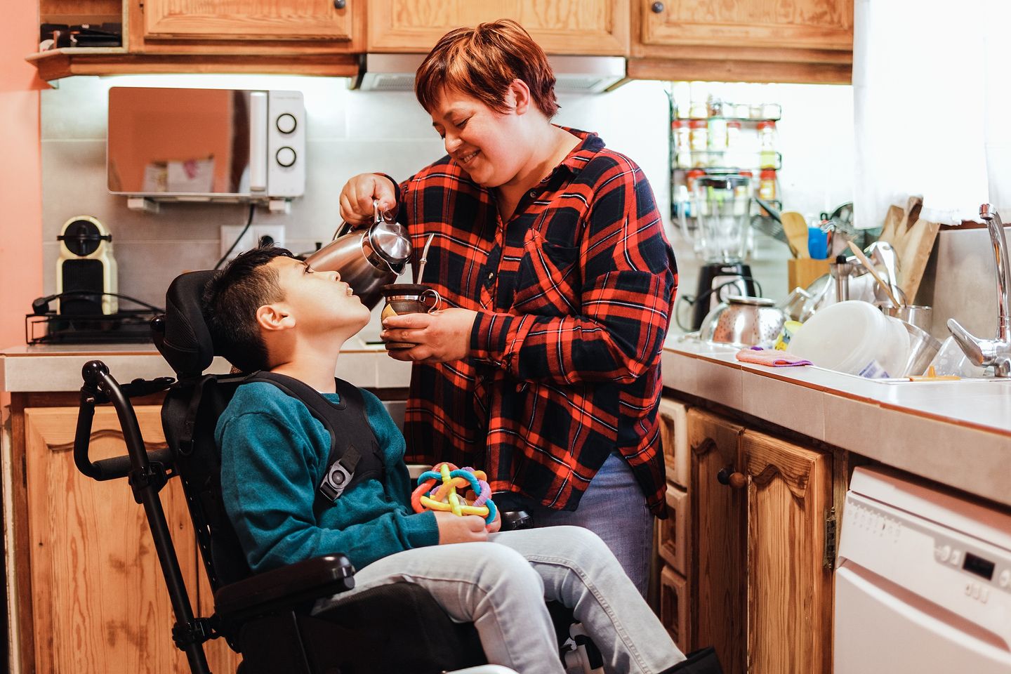 a mother feeding her child who is using a wheelchair