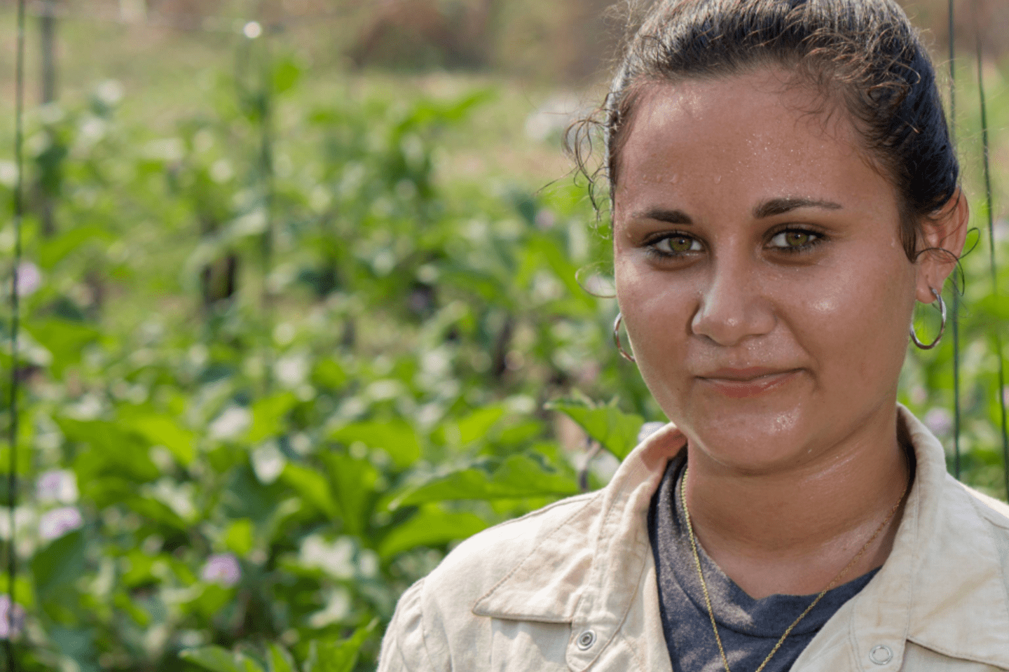 Primer plano de mujer agricultora sobre un paisaje de un cultivo. 