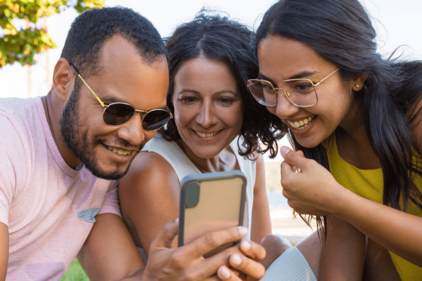 Group of people looking at a cellphone.