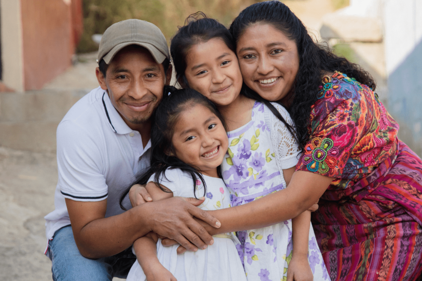 A migrant family embraces outside their home 