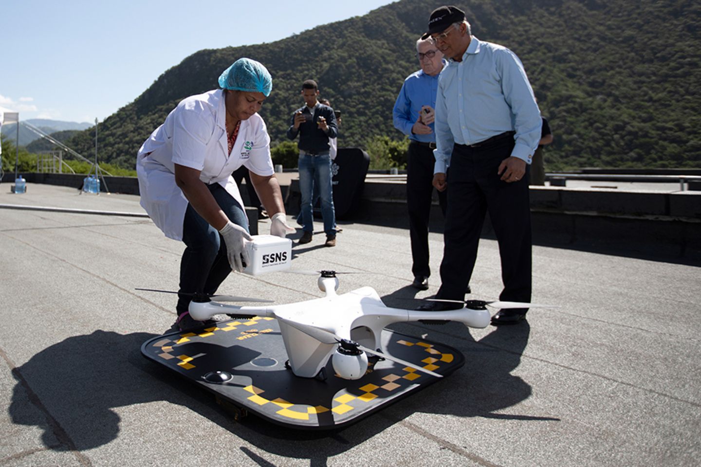 Healthcare personnel load medical devices onto a drone.