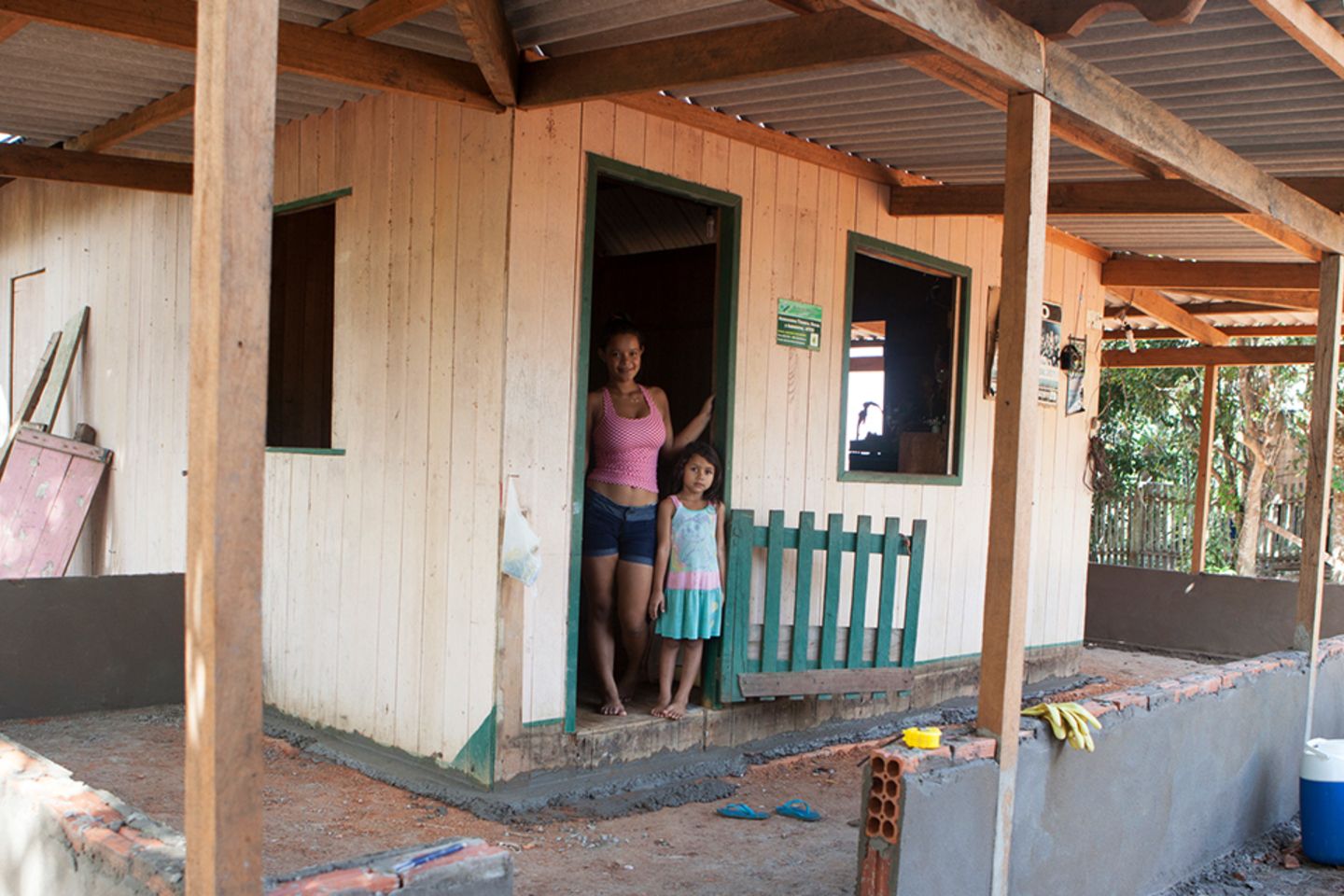 Woman and girl on the threshold of their house.