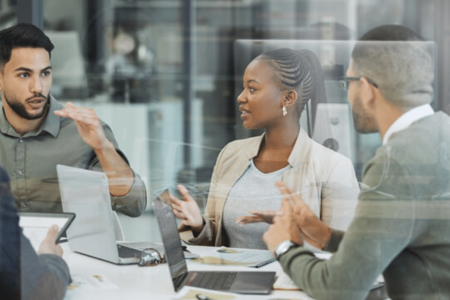 Image with four people negotiating services in a meeting room