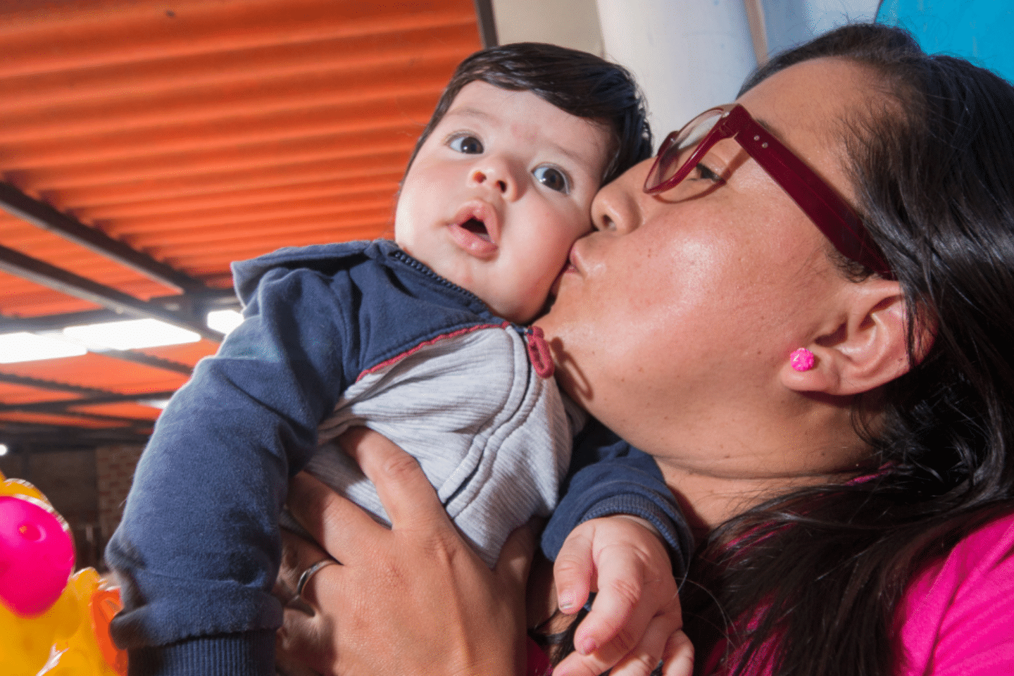 Cuidadora dando un beso a un bebé